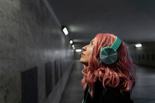 Woman With Pink Dyed Hair Listening Music Through Headphones