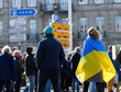 Rear view of woman wearing Ukrainian flag walking on street at protest in front of Russian Consulate solidarity Ukrainians against the war after Russian invasion