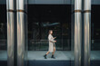© ADDICTIVE STOCK - Woman with smartphone near modern building
