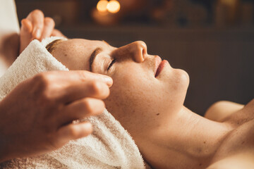 Wall Mural - the caucasian freckled woman has a facial treatment at beauty spa salon. healthy lifestyle. facial b