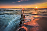 Fototapeta Fototapety z morzem do Twojej sypialni - Morze bałtyckie. Plaża w miejscowości Chałupy - półwysep helski, o wschodzie słońca. Duże fale, piasek, wybrzeże, słońce, woda i falochron