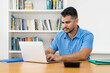 © Daniel Ernst - Hispanic hipster man with beard working with concentration at computer