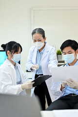 a professional asian senior female doctor training two asian junior specialist in the lab.