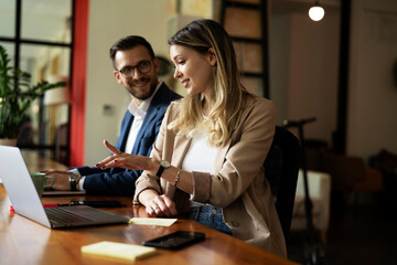 Canvas Print - Colleagues in office. Businesswoman and businessman discussing work in office.