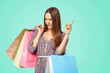 © Dmytro Panchenko - Happy beautiful woman with shopping bags and pointing finger isolated.