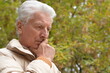 © aletia2011 - Serious senior man looking in park on green background