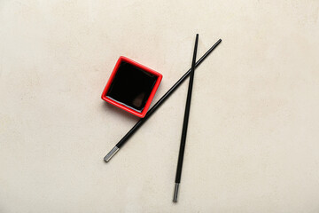 Wall Mural - Red bowl of soy sauce and chopsticks on white background