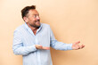 © luismolinero - Middle age caucasian man isolated on beige background with surprise expression while looking side