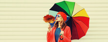 Autumn Portrait Of Happy Cheerful Young Woman With Colorful Umbrella And Yellow Maple Leaves Wearing Red Coat And Beret On White Background