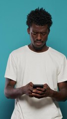 confused man using smartphone for text messages and browsing internet. portrait of modern person loo