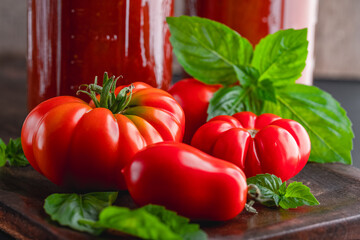 Sticker - Fresh ripe, whole tomatoes, basil and home canned tomato sauce on a wooden cutting board