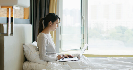 Poster - Woman work on laptop computer on bed