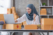 © David - Muslim Young Asian business woman startup sme small business entrepreneur SME distribution warehouse with parcel mail box. Muslim girl SME Online marketing and product packaging and delivery service.