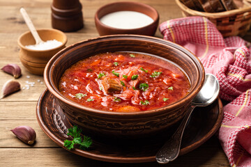 Wall Mural - Traditional Ukrainian soup borscht in bowl on wooden background