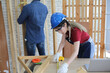 © FotoArtist - Side view portrait of modern female carpenter measuring wooden part making furniture over working table in workshop