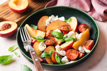 Wall Mural - Healthy summer fruit and cheese salad with peach, mozzarella, cherry tomatoes and basil