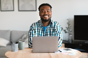 Wall Mural - Successful African American Male Entrepreneur Using Laptop Posing At Workplace