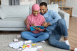 © Prostock-studio - Preparing For Childbirth. Pregnant Muslim Spouses Making Checklist Of Necessities At Home
