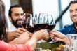 leisure, people and celebration concept - close up of happy friends drinking red wine and toasting at restaurant or pub