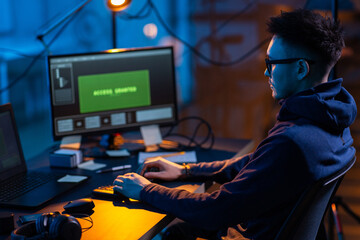 Poster - cybercrime, hacking and technology concept - male hacker in dark room writing code or using computer virus program for cyber attack