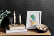 © Syda Productions - interior and home decor concept - bench with burning candles, picture in frame, books, seashells and eucalyptus branches over black background