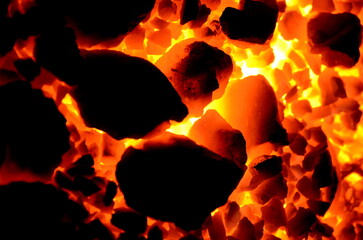 Poster - 
Orange-black background of burning coal anthracite of different fractions.