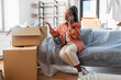 © Syda Productions - moving, people and real estate concept - angry woman with boxes calling on smartphone at new home