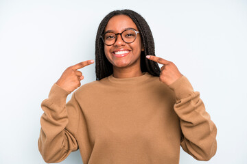 Wall Mural - black young adult woman smiling confidently pointing to own broad smile, positive, relaxed, satisfied attitude