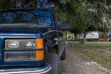 Old Blue Chevy K1500 Silverado Pickup From Late 90s With Custom Black Wheels Sitting Outdoors In Nature With Aftermarket Headlights