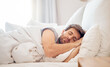 © N Felix/peopleimages.com - Home, bedroom and sleeping man in the morning lying his head on the pillow in apartment space. Tired, fatigue and relax male taking time off on the weekend in bed of airbnb or hotel accommodation