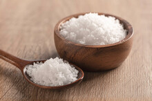 Sea Salt In A Wooden Bowl And Spoon On Wooden Table .