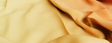 Yellow And Orange Textile With Wrinkles And Folds. Multicolored Luxury Surface Wallpaper.