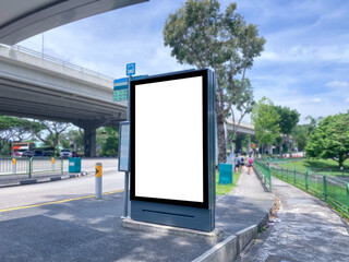 Blank vertical advertising poster banner mockup at empty bus stop shelter by main road, greenery behind. Out-of-home OOH vertical billboard media display space under expressway highway.