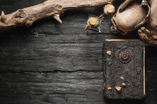 Magic Book, Skull And Burning Candle On The Old Wooden Table Background With Copy Space.