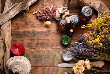 Wall Mural - Herbal medicine concept background. Dry natural ingredients and remedy bottle on the wooden table background with copy space. Top view.