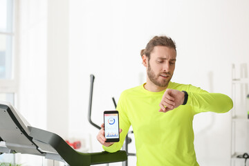 Sticker - Sporty young man using phone with installed app for calories counting in gym