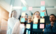 © Arnéll Koegelenberg/peopleimages.com - Creative group or business team planning for innovation with sticky notes on glass wall. Coach or leader sharing vision and mission in a meeting. Manager sharing ideas and explaining strategy