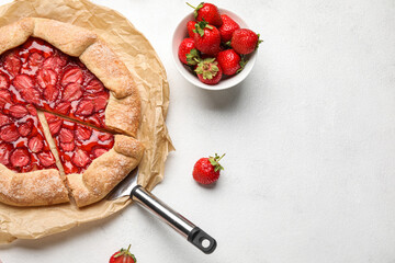 Wall Mural - Delicious strawberry galette and bowl of fresh berries on light background