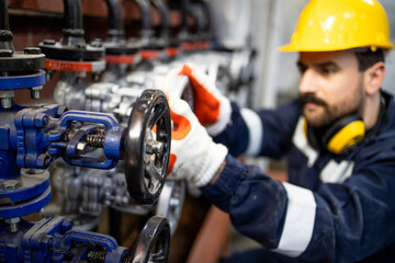 Wall Mural - Professional worker tightening industrial valve in factory.