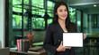 © Prathankarnpap - Gorgeous millennial businesswoman showing digital tablet with white display and smiling at camera
