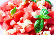 © vaaseenaa - Watermelon salad with feta cheese and basil in plate, gray background. Summer recipe, healthy diet.