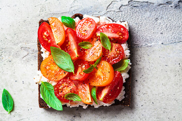 Wall Mural - Rye toast with cream cheese, tomatoes and basil. Healthy breakfast recipe.