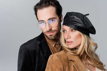 Wall Mural - blonde woman in stylish beret near bearded man in sunglasses looking at camera isolated on grey