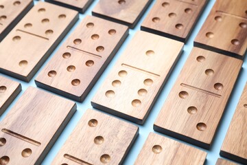 Wall Mural - Wooden domino tiles on light blue background, closeup