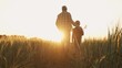 © Acronym - Farmer and his son in front of a sunset agricultural landscape. Man and a boy in a countryside field. Fatherhood, country life, farming and country lifestyle.