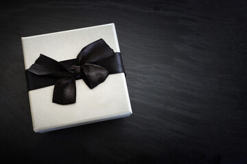 Grey gift box on dark textured background. Top view