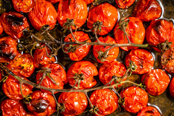 Background with roasted cherry tomatoes with garlic, olive and thyme