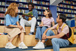 © Seventyfour - Full length shot of multiethnic students studying together in library with vibrant blue colors