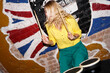 © brillianata - A young cheerful blonde plays a drum set for a computer game. Party entertainment. Cheerful bachelorette or birthday party. Brick wall on background