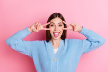 Photo Of Dreamy Cute Young Woman Dressed Blue Cardigan Showing V-signs Near Her Head Tongue Isolated On Pink Color Background